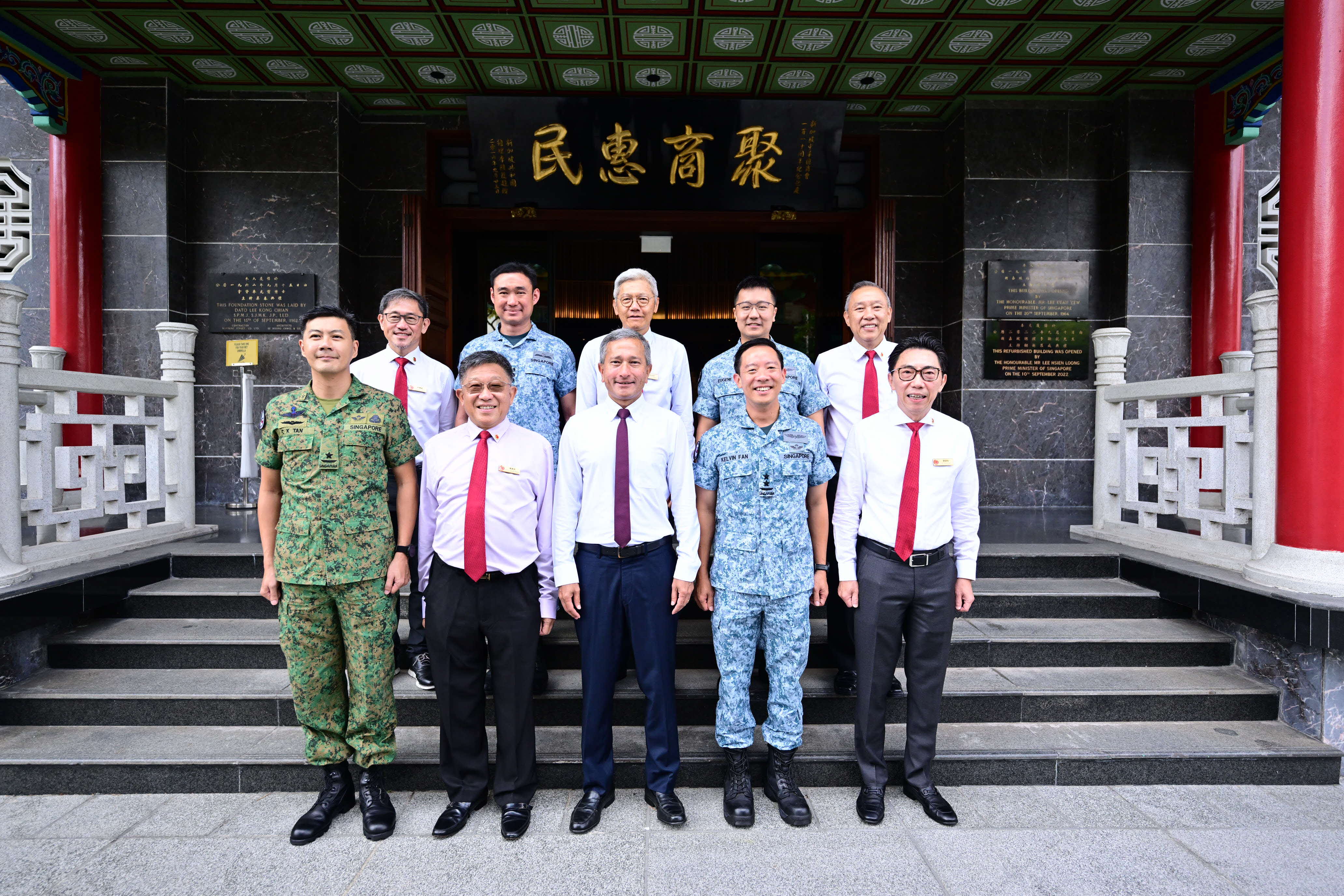 People at a meeting table with Singapore, Austria, and EU flags behind them.